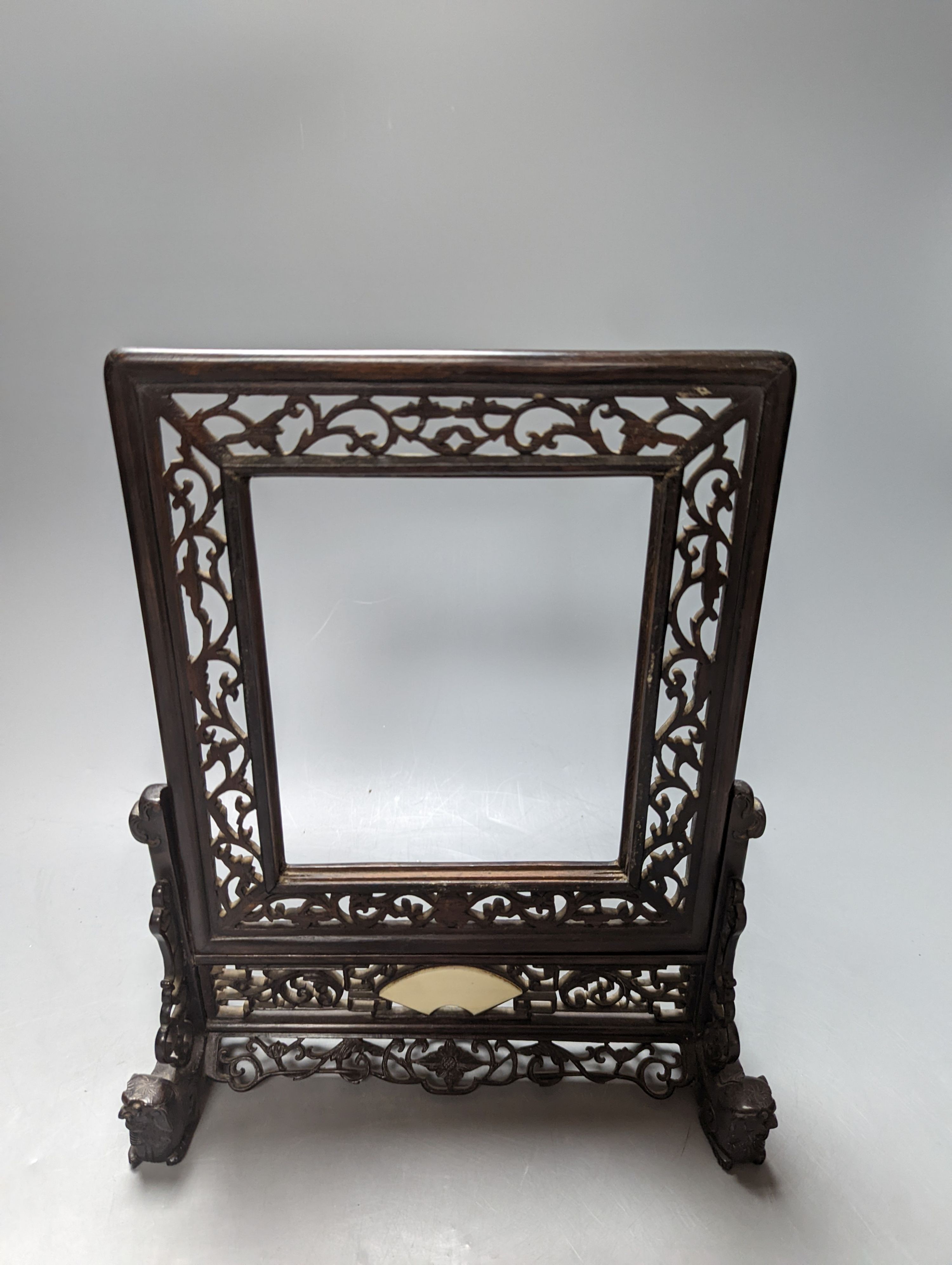 A Chinese hardwood carved table screen, frame and stand, 30 cms high.